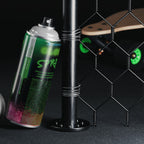 Leuchtspray Natur-Grün 400 ml: Dose im Dunkeln neben Stange, Skateboard und Maschendrahtzaun