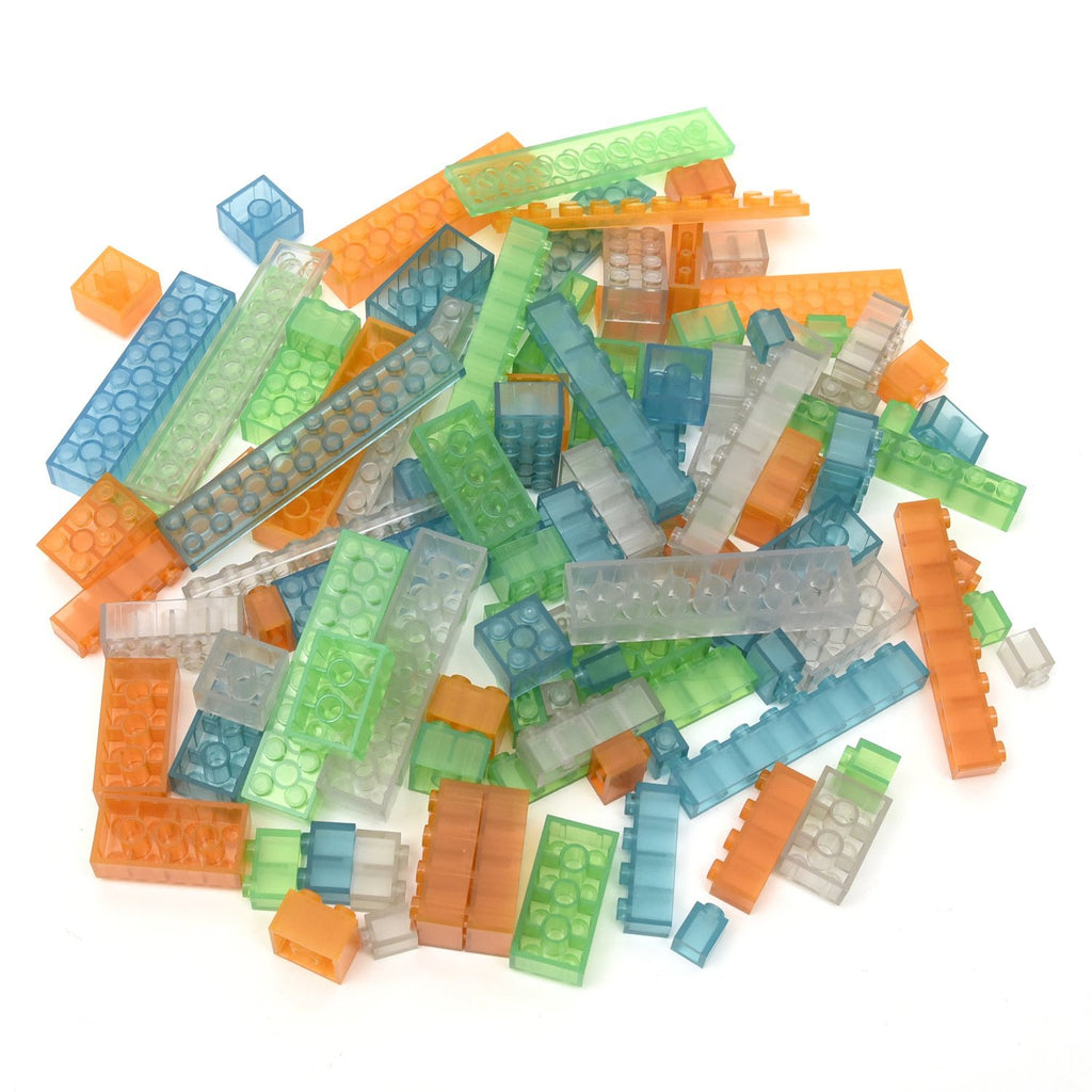 Leuchtende Klemmbausteine in 4 Farben bei Tageslicht: transparente Steine in Orange, Blau, Grün und Farblos