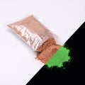 Feinpigment Terracotta 100 g: aufgeschnittener Beutel und Häufchen feines Pulver, bei Tag bräunlich, rechts unten im Dunkeln grün leuchtend