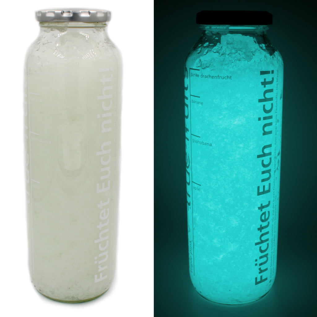 Glasflasche mit Leucht-Gelee Natur/Blaugrün nebeneinander: links bei Tageslicht, rechts im Dunkeln leuchtend