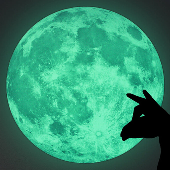 Mond-Aufkleber im Dunkeln leuchtend, davor der Schatten einer Hand