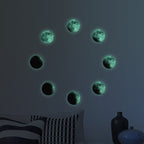 Mond-Aufkleber als Mondphasen im Kreis an einer Wand, im Dunkeln leuchtend über einem Bett