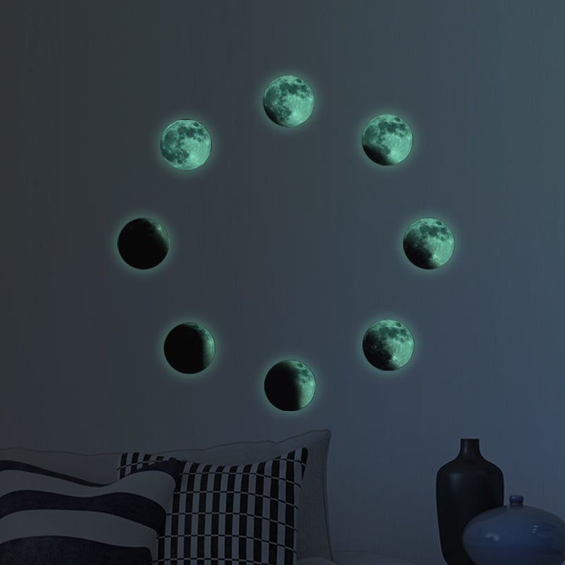 Mond-Aufkleber als Mondphasen im Kreis an einer Wand, im Dunkeln leuchtend über einem Bett