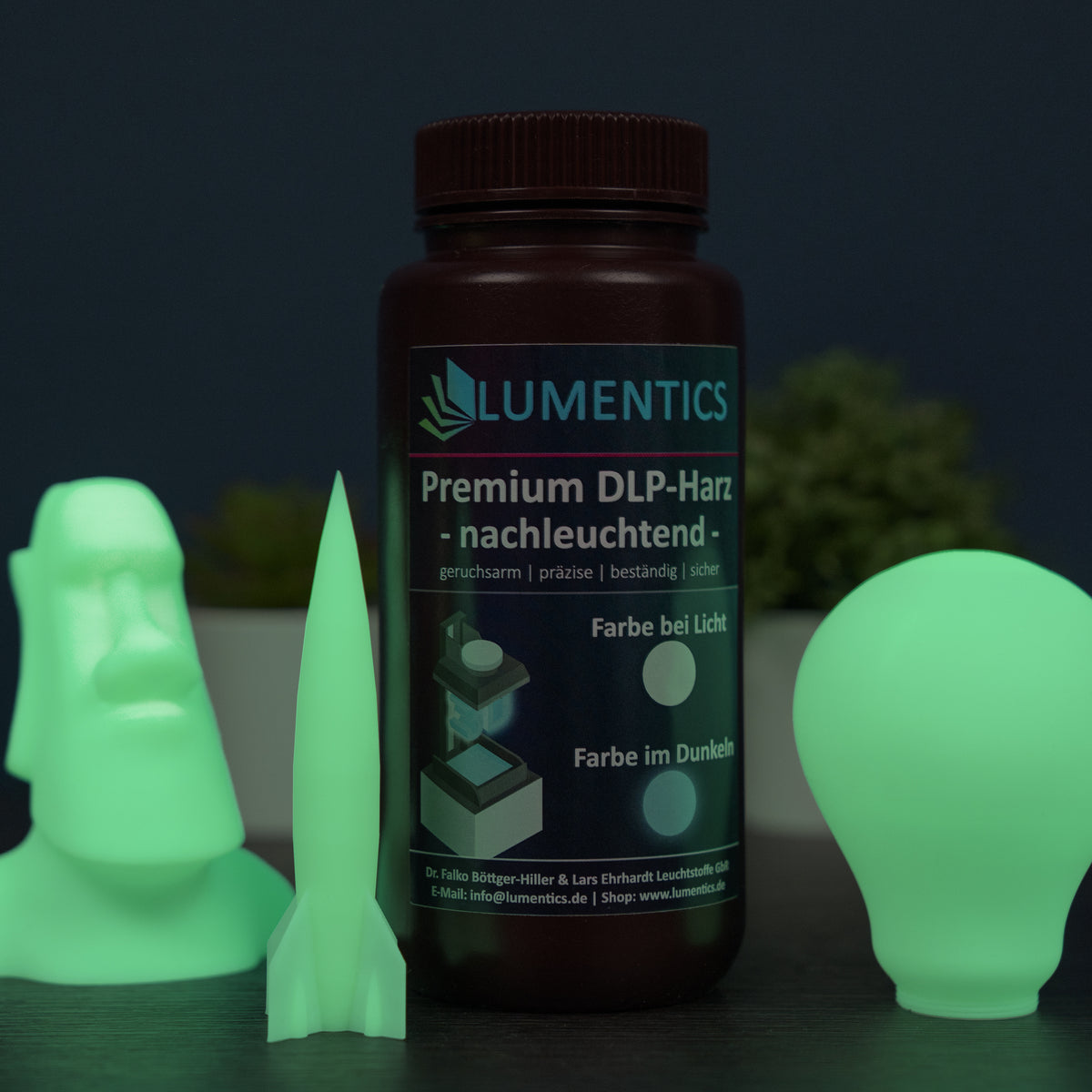 3D-Druckharz Grün 500 g: Flasche mit drei gedruckten, grün leuchtenden Objekten: Figur, Rakete, Glühbirne