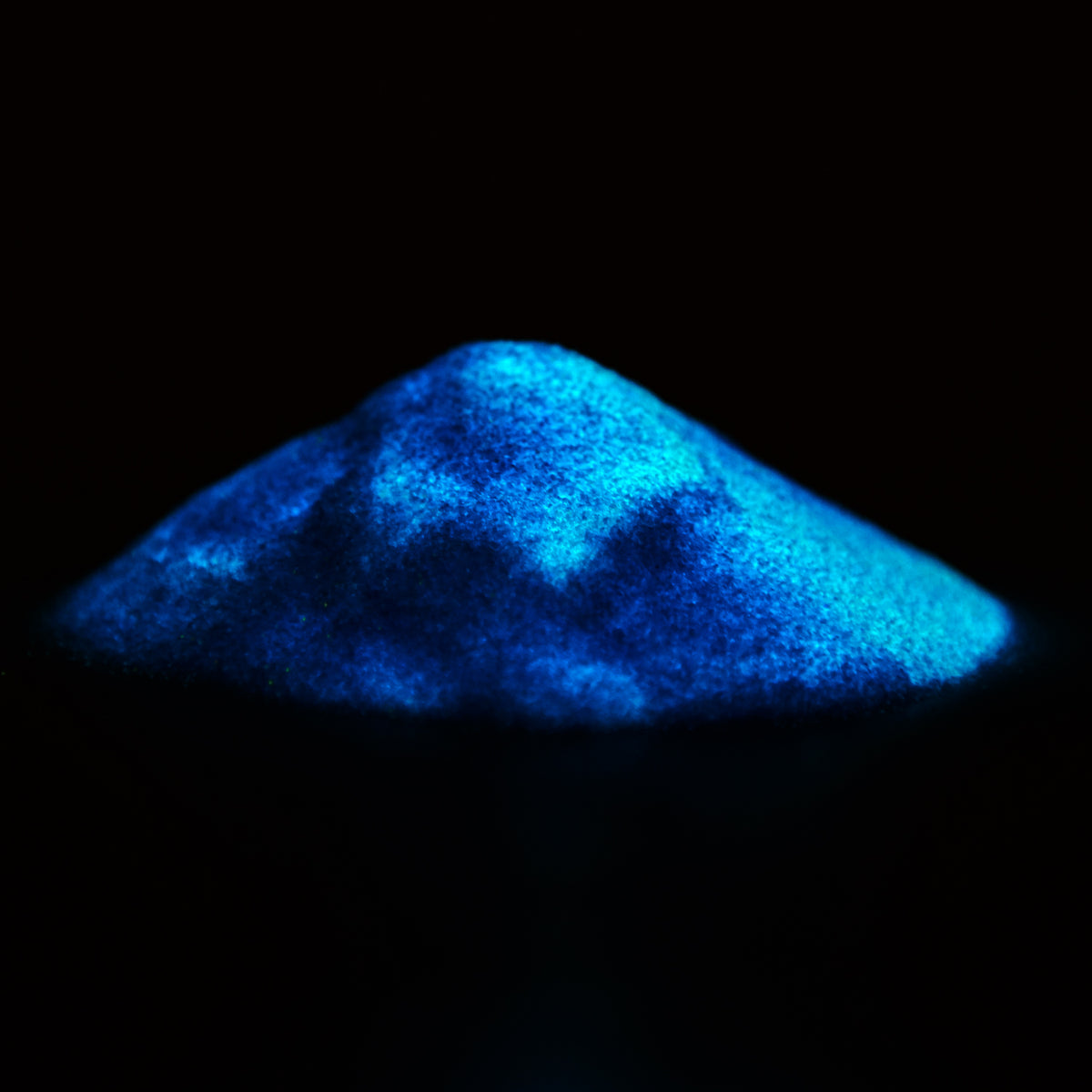 Haufen Glitzerpulver Blau 50 g im Dunkeln, das Pulver leuchtet blau
