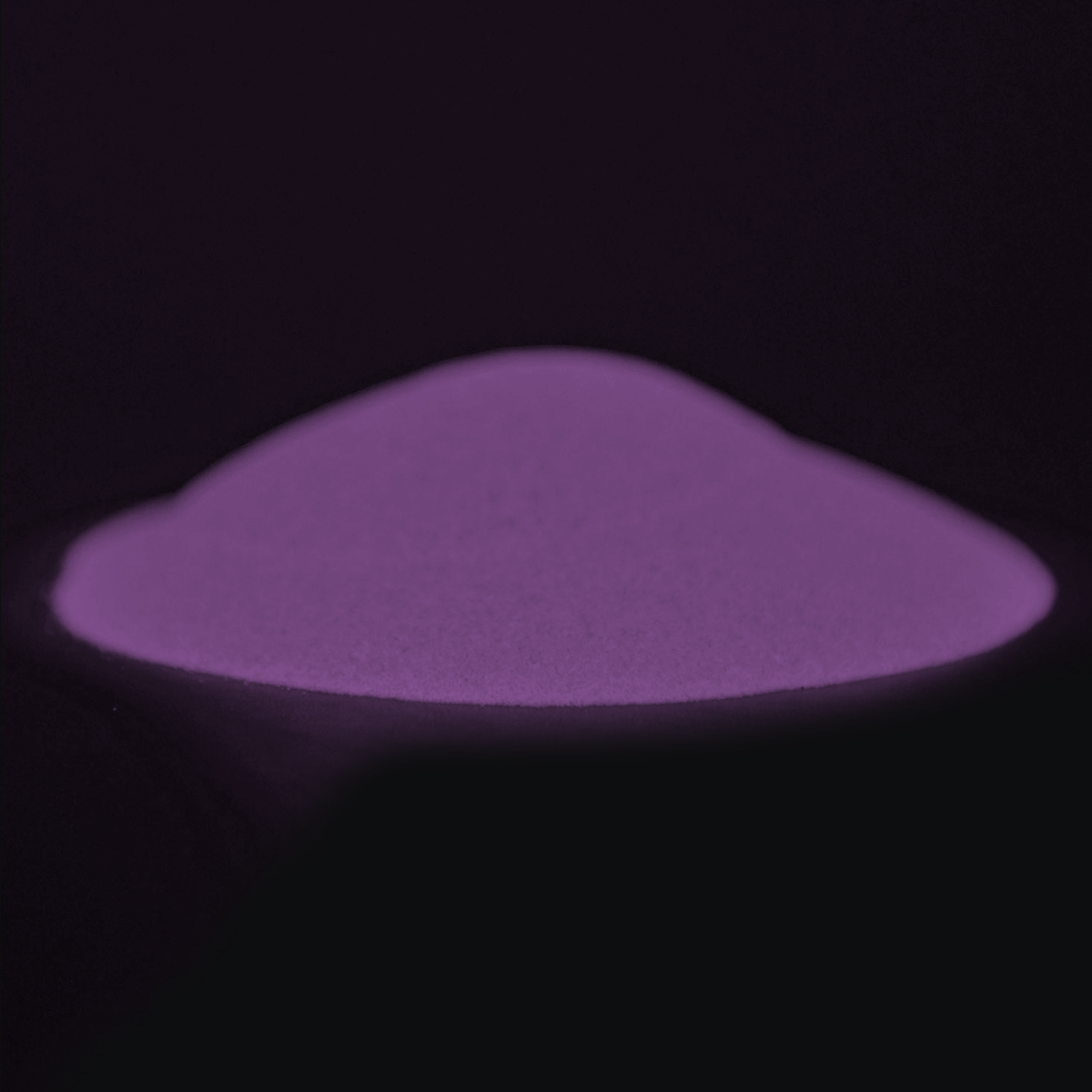 Leuchtpulver Pink-Oceanpink 40 g: Pulverhäufchen im Dunkeln mit violettem Nachleuchten