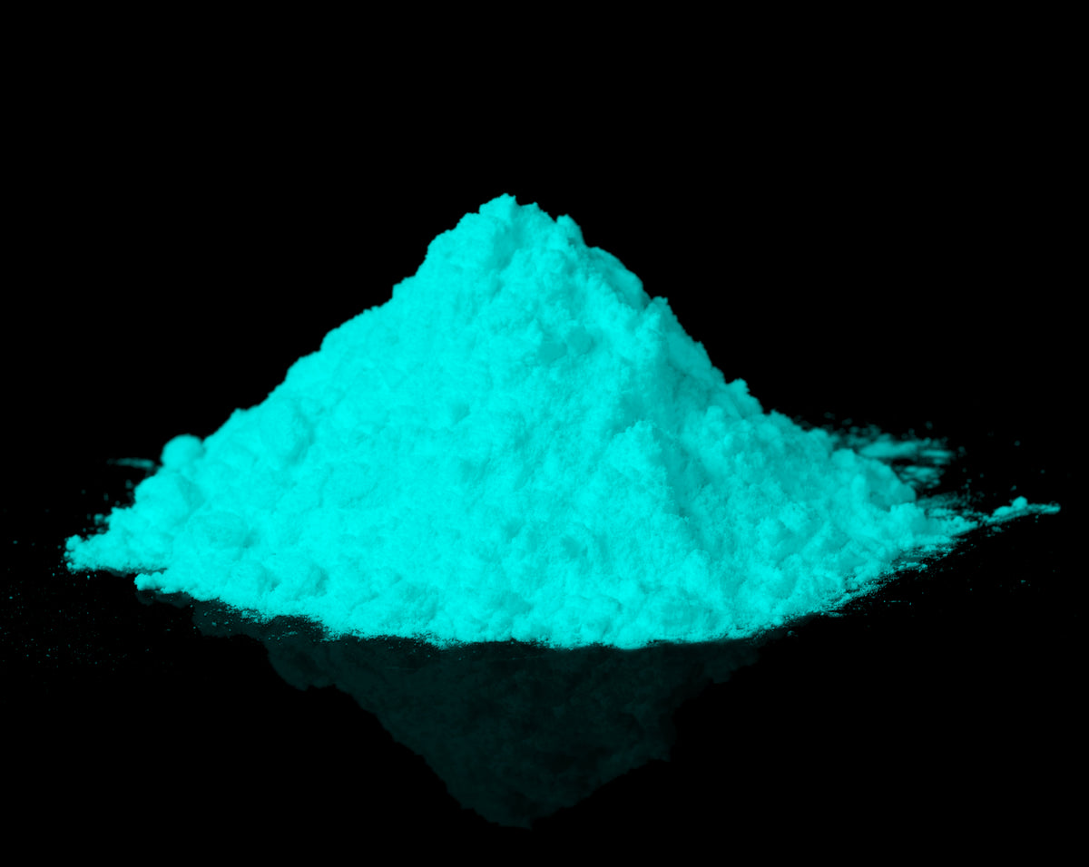 Leuchtpulver Natur-Grünblau 40 g: Pulverhaufen auf schwarzem Grund im Dunkeln, leuchtend