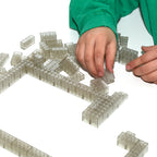 Transparente Klemmbausteine 2x4, Hand legt Steine an eine lange Reihe an